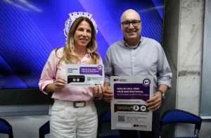 A secretaria Alessandra Herrmann e o prefeito Dario Saadi seguram avisos que devem ser afixados pelos signatarios do pacto Ninguem se Cala Foto Adriano Rosa